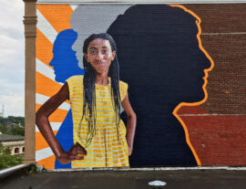 Fearless Girl Mural painted by Charles C. Clear III and Bonnie Lee Turner on the exterior of Beacon Charter High School for the Arts in Woonsocket, RI