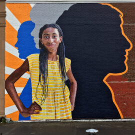 Fearless Girl Mural painted by Charles C. Clear III and Bonnie Lee Turner on the exterior of Beacon Carter School in Woonsocket, RI