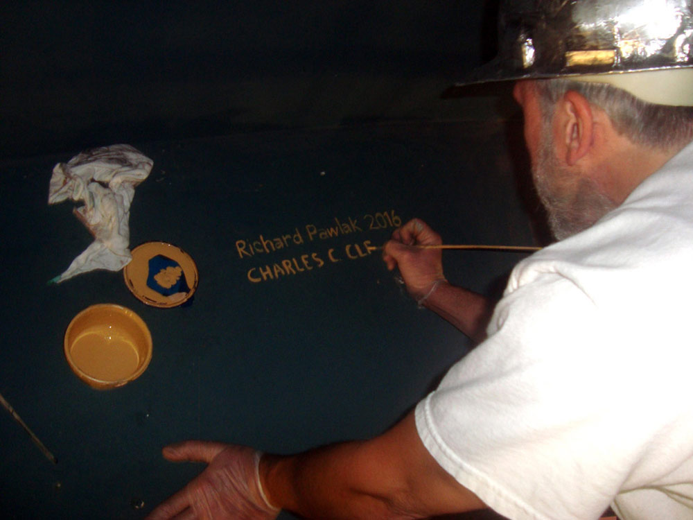 Artist Charles C. Clear III signs his name upon completing the work inside the Dome of the Rhode Island State House
